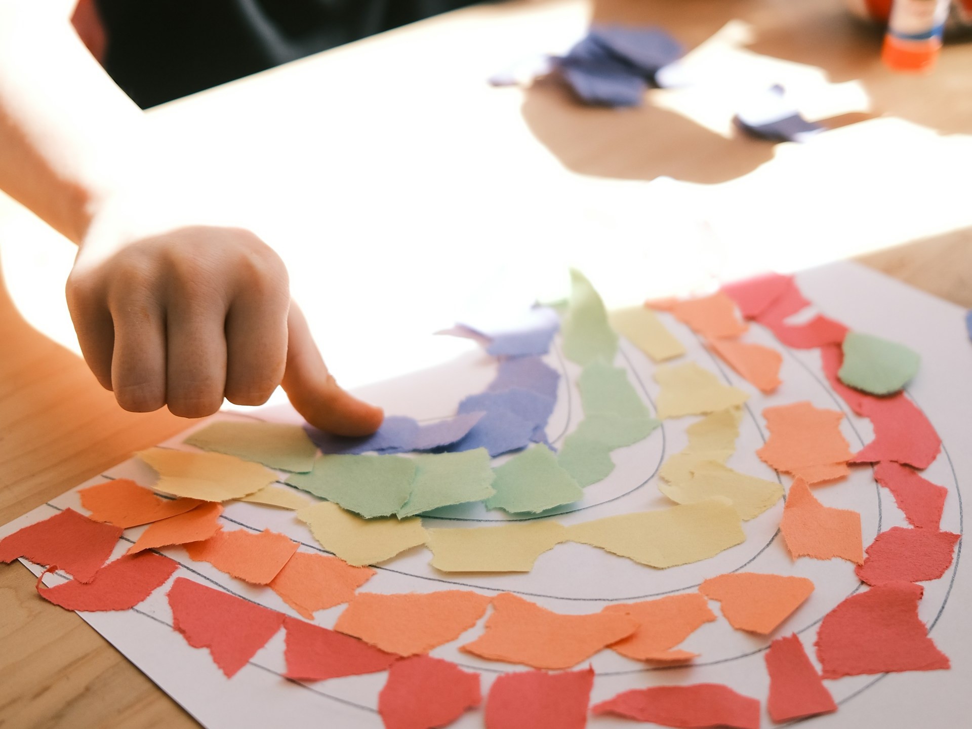 Close-up photo of someone making a rainbow from scraps of paper