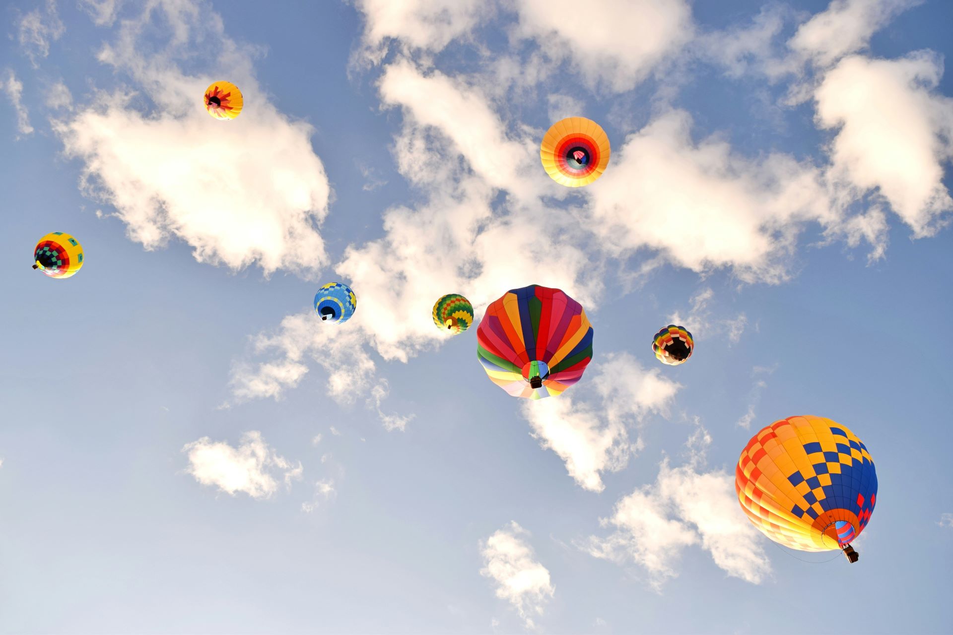 Hot air balloons in a blue sky viewed from below